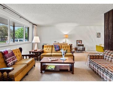 Cozy living room featuring classic furnishings and a large window offering plenty of natural light at 3018 S Depew St, Denver, CO 80227