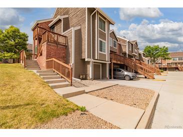 Inviting townhome featuring wood and brick facade with wooden stairs and partial basement at 2296 S Pitkin Way # A, Aurora, CO 80013