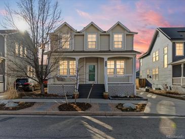 Charming two-story home featuring a cozy front porch and landscaped front yard perfect for enjoying neighborhood views at 2755 Geneva St, Denver, CO 80238