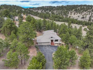 Beautiful home nestled in a wooded area with a large driveway and a charming tiled roof at 2122 Montane Dr, Golden, CO 80401