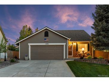 Charming single-story home with a two-car garage, well-manicured lawn, and inviting front porch at 11076 Cotton Creek Dr, Westminster, CO 80031