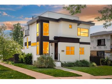 Modern two-story home featuring sleek architectural lines, a beautiful front yard, and abundant natural light at 2990 Osceola St, Denver, CO 80212