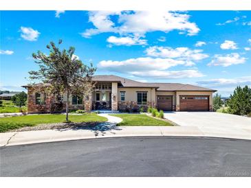 Beautiful single-story home featuring stone accents, a landscaped yard, and a two-car garage on a sunny day at 372 Castlemaine Ct, Castle Rock, CO 80104