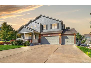 Beautiful two-story home with a brick-accented three-car garage and cozy covered front porch at 3779 Aspen Hollow Ct, Castle Rock, CO 80104