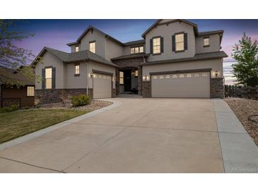 Stunning two-story home with stone accents and three-car garage on a well-manicured lawn at 17452 W 83Rd Pl, Arvada, CO 80007