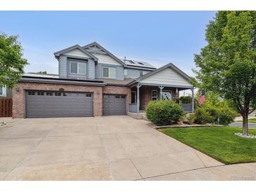 Inviting two-story home with brick accents, covered porch, and a three-car garage at 26155 E Euclid Dr, Aurora, CO 80016