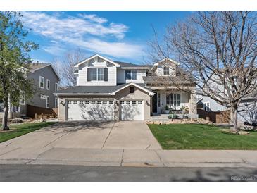 Spacious home with a three-car garage and well-maintained lawn, providing ample parking and curb appeal at 9877 Arthur Ln, Highlands Ranch, CO 80130