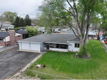 Charming single-story home with a two-car garage, front porch, and spacious, tree-lined backyard at 14185 W 50Th Ave, Golden, CO 80403