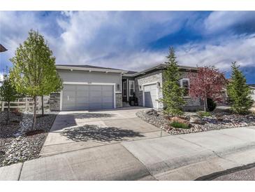Charming home featuring a two-car garage, stone accents, and landscaped front yard at 5251 Silver Hare Ct, Castle Rock, CO 80104