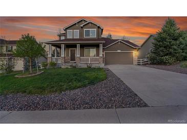 Charming two-story home boasting a covered front porch, well-manicured lawn, and an attached two-car garage at 3790 Aspen Hollow Ct, Castle Rock, CO 80104