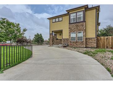 Stylish two-story home with a stone and siding exterior, concrete driveway, and manicured lawn at 4190 W Alameda Ave, Denver, CO 80219