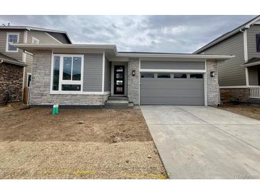 Charming single-story home with stone and gray siding, a concrete driveway, and an attached two-car garage at 24738 E 40Th Ave, Aurora, CO 80019