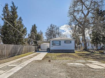 Charming single-story home with a long driveway and carport, surrounded by mature trees at 2650 W Mississippi Ave, Denver, CO 80219