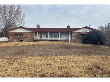 Ranch style home with red roof and stone facade at 6397 Ute Hwy, Longmont, CO 80503