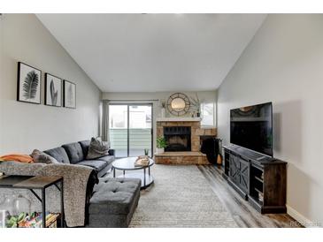 Inviting living room featuring a stone fireplace and sliding glass doors for natural light at 4108 S Rifle Way, Aurora, CO 80013