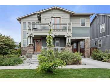 Inviting two-story home featuring a spacious porch, balcony, and a well-maintained landscaped front yard at 8464 E 55Th Pl, Denver, CO 80238