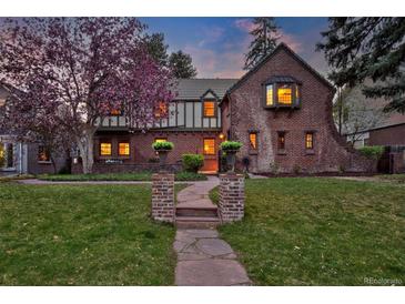 Charming two-story brick home with lush landscaping and a stone walkway leading to the front door at 239 Ash St, Denver, CO 80220