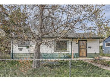 Charming single-story home featuring a fenced yard, decorative door, and a mature shade tree in the front at 925 Quitman St, Denver, CO 80204
