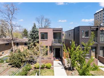 Modern two-story brick home featuring a balcony and lush landscaping at 1833 E Jewell Ave, Denver, CO 80210