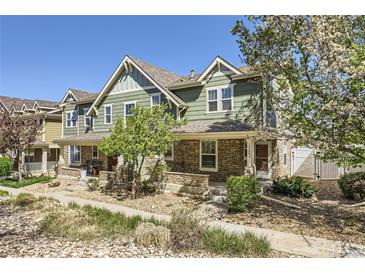 Inviting exterior showcasing a well-maintained, two-story home with charming stone accents and a lush, landscaped yard at 17244 E Kansas Dr, Aurora, CO 80017