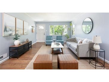 Bright living room with hardwood floors, modern furniture, and large windows providing natural light at 8240 Grandview Ave, Arvada, CO 80002