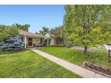 Charming home featuring a well-manicured lawn and mature trees under a clear blue sky at 1292 Kearney St, Denver, CO 80220