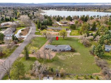 Expansive aerial view of a single-story home near a tranquil lake surrounded by lush trees and verdant lawns at 4901 Redwood Dr, Littleton, CO 80123