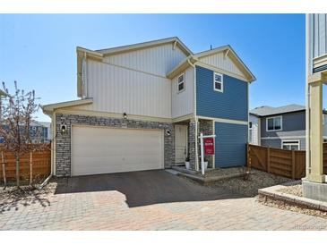 Beautiful two story home with mixed stone and siding, attached garage, and well maintained front yard at 10207 Xanadu St, Commerce City, CO 80022