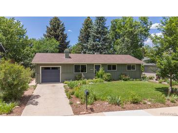 Charming single-story home with a lush green lawn, mature trees, and an attached garage at 3545 Cloverleaf Dr, Boulder, CO 80304