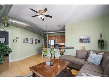 Inviting living area featuring hardwood floors, breakfast bar, and comfortable brown sectional at 277 N Broadway # 403, Denver, CO 80203