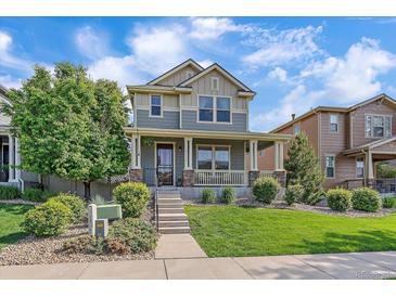 Charming two-story home featuring a welcoming front porch and beautifully landscaped front yard at 21392 E Stroll Ave, Parker, CO 80138