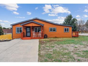 Charming single-story home with orange siding, cozy front porch, and well-maintained lawn at 176 W Elm St, Elizabeth, CO 80107