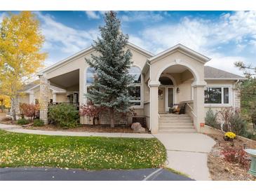 Inviting single-Gathering home with charming stucco exterior, mature landscaping, and covered porch at 740 W Lancers Ct, Monument, CO 80132