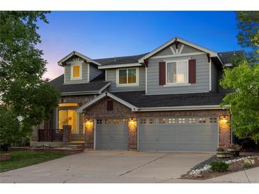 Charming two-story home with a brick facade, two-car garage, and manicured front yard at 10039 Heatherwood Pl, Highlands Ranch, CO 80126