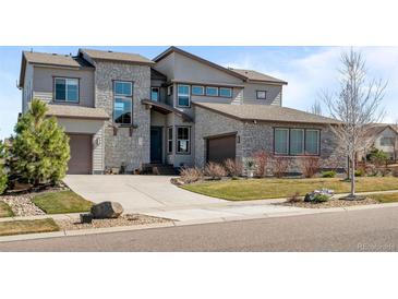 Beautiful home featuring a stone and siding exterior, professional landscaping, and a large driveway leading to an attached garage at 8172 S Langdale Way, Aurora, CO 80016