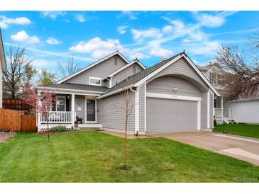 Charming two-story home with a well-manicured lawn, gray siding, and a front porch perfect for relaxing at 21733 Saddlebrook Dr, Parker, CO 80138