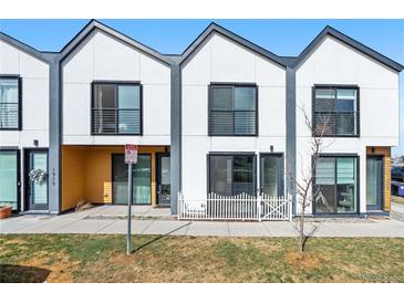 A modern townhome featuring sleek architecture and a well-manicured front yard at 1907 W Elk Pl, Denver, CO 80211