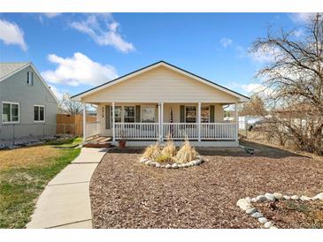 Charming home featuring a covered front porch, well maintained yard and beautiful curb appeal at 2019 S Fox St, Denver, CO 80223