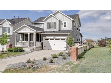 Charming two-story home with a two car garage, inviting porch, and beautifully landscaped front yard at 27655 E Geddes Pl, Aurora, CO 80016