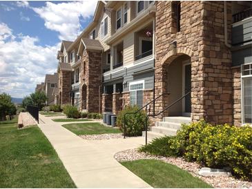 Beautiful multi-story townhomes featuring stone accents, well-maintained landscaping, and inviting entryways at 452 Black Feather Loop # 612, Castle Rock, CO 80104