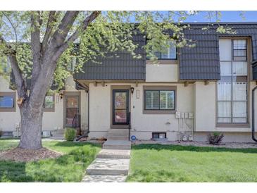 Charming townhome featuring a landscaped front yard and classic architectural details at 6844 S Broadway, Littleton, CO 80122
