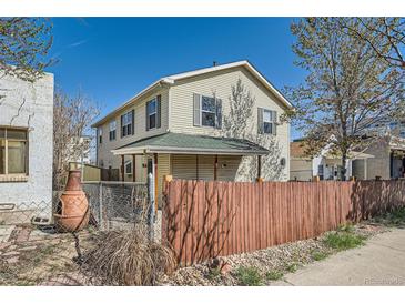 Charming two-story home featuring vinyl siding, well-maintained landscaping, and a wood fence in the front yard at 3334 Navajo St, Denver, CO 80211