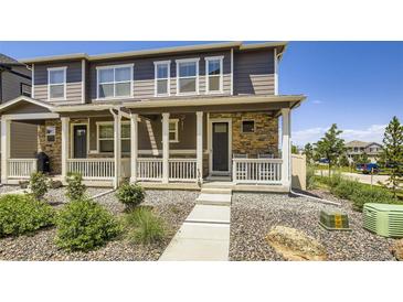 Charming two-story townhome with a stone facade and a welcoming covered porch at 7022 Todd Ct, Frederick, CO 80530
