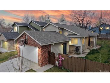 Charming home with a two-car garage, brick accents, and colorful decorations at 464 Chiswick Cir, Highlands Ranch, CO 80126