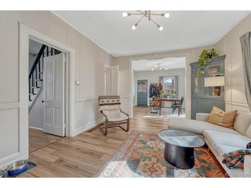 Inviting living room featuring hardwood floors, neutral paint, and an open floor plan to the dining room at 2819 W 43Rd Ave, Denver, CO 80211