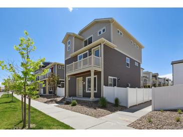 Two-story home with gray and beige siding, white trim, and small balcony over front door at 5121 N Yampa St, Denver, CO 80249