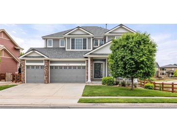 Charming two-story home featuring a three-car garage, well-maintained lawn and mature landscaping at 16120 E 119Th Ave, Commerce City, CO 80022