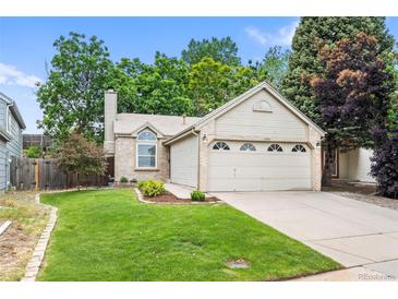 Charming home with a well-manicured front lawn and an attached two-car garage in a quiet neighborhood at 17692 E Brunswick Pl, Aurora, CO 80013