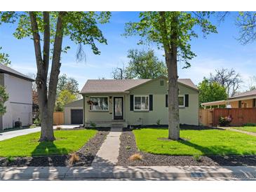 Charming single story home with mature trees, lawn, and a cozy, inviting facade at 949 Pontiac St, Denver, CO 80220