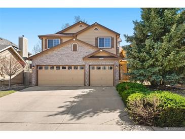 Charming two-story home with a well-manicured lawn and an attached two-car garage at 12710 W 84Th Cir, Arvada, CO 80005